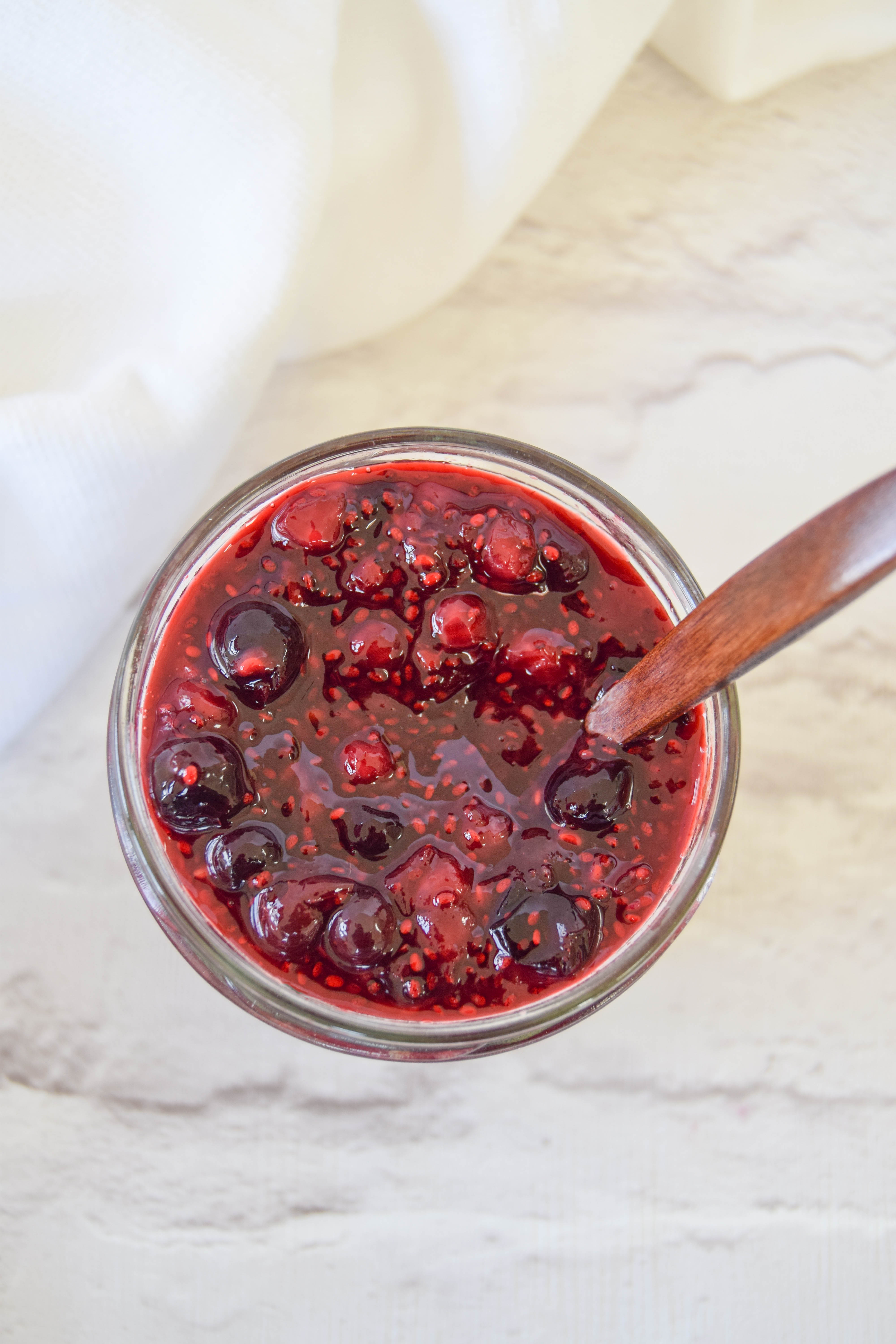 A delicious creamy coconut porridge breakfast bowl topped with a juicy homemade chia berry compote.