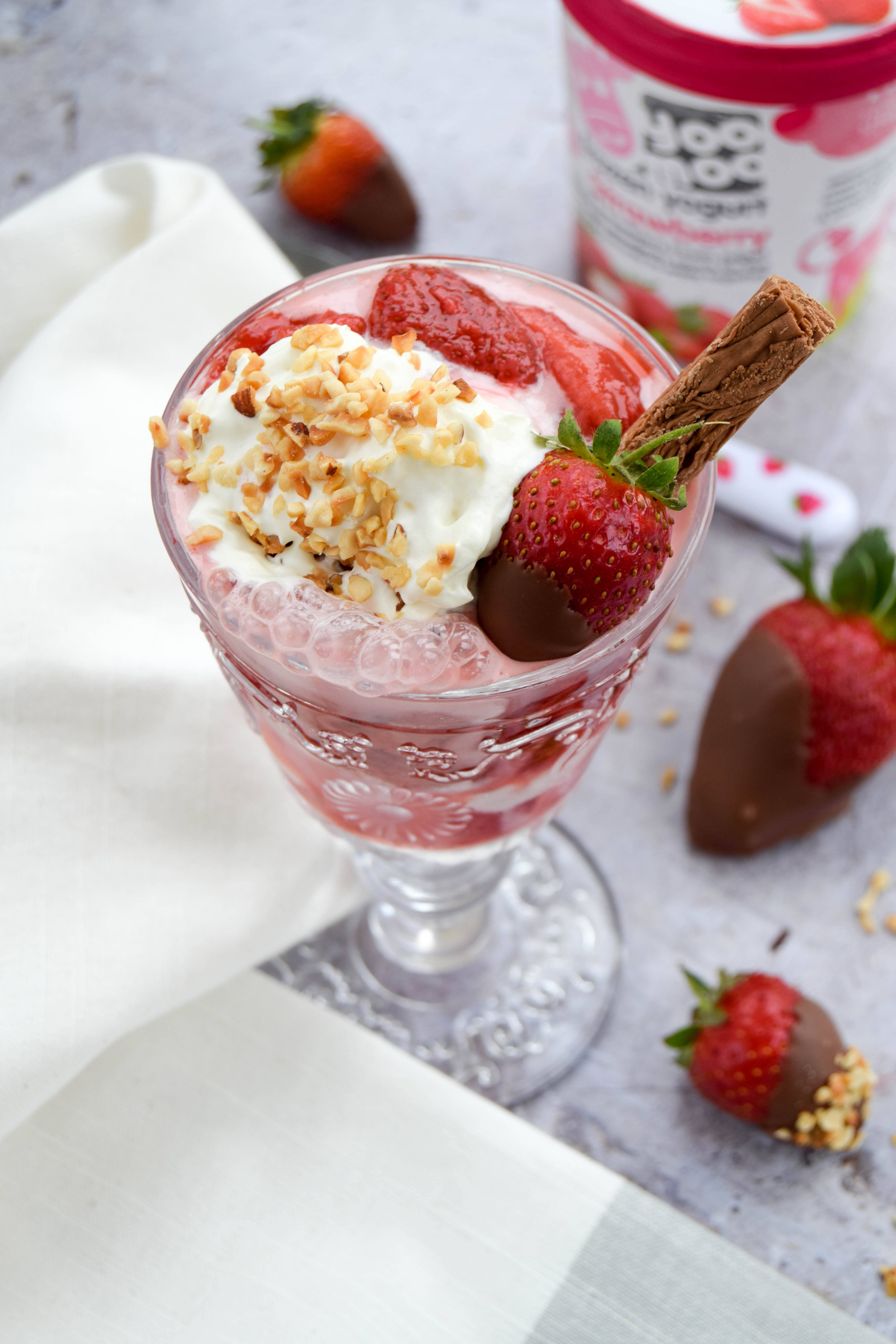 A fruity and vibrant strawberry sundae dessert topped with chocolate covered strawberries - perfect to serve at BBQ's and all your upcoming summer parties. 