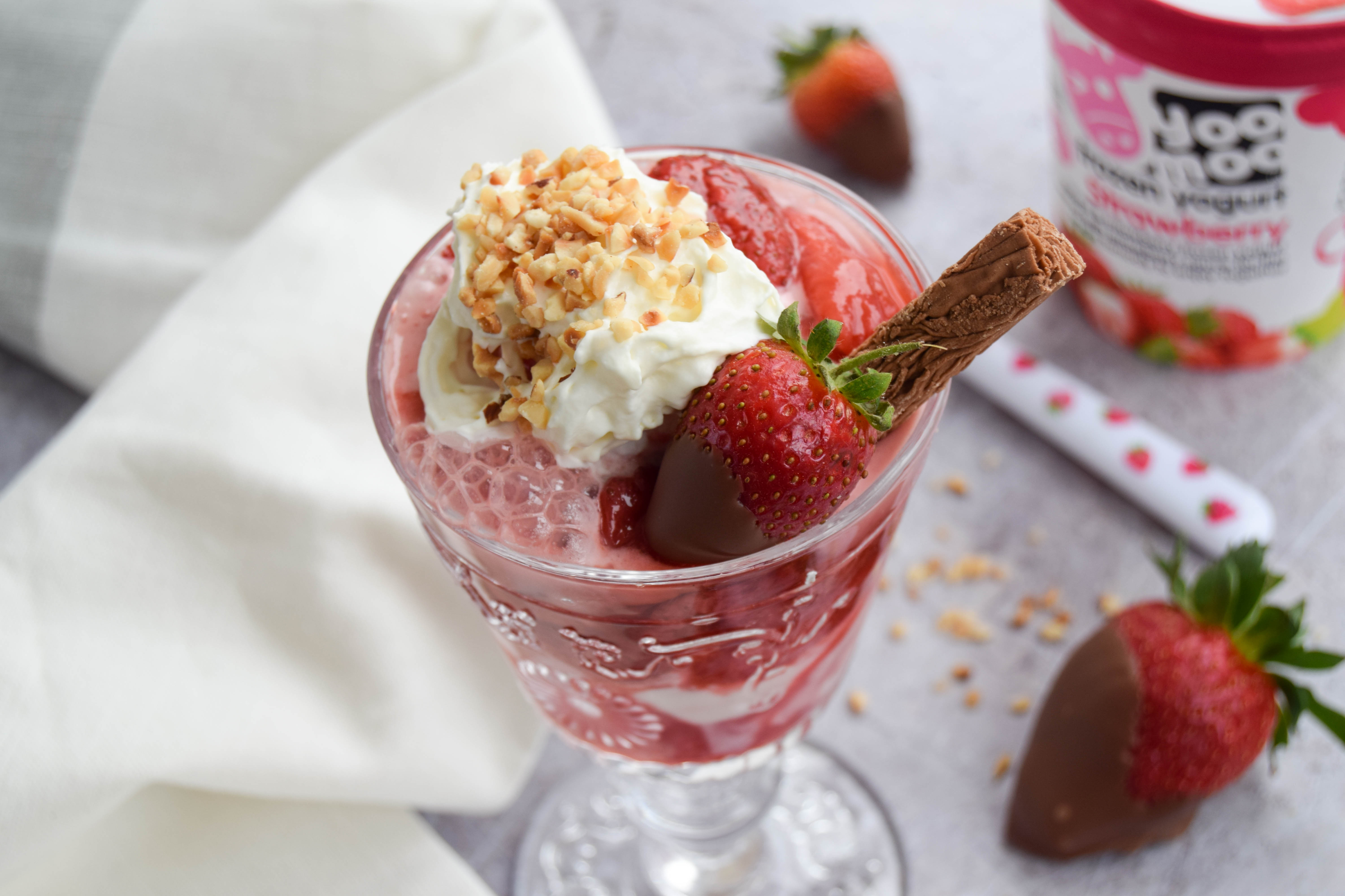A fruity and vibrant strawberry sundae dessert topped with chocolate covered strawberries - perfect to serve at BBQ's and all your upcoming summer parties. 