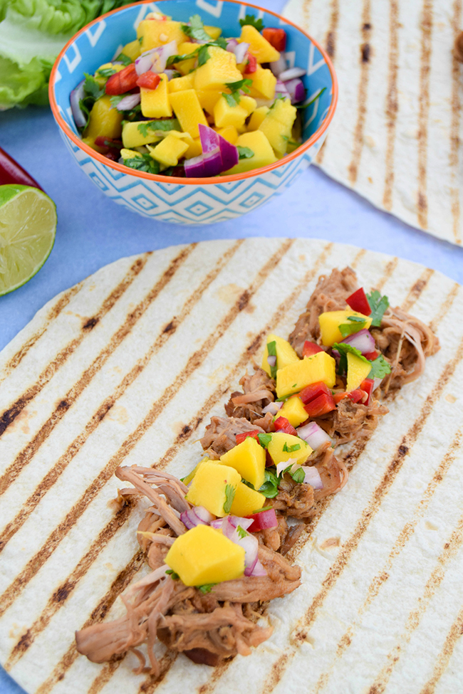 Think your slow cooker is just for winter? Dust it off and try these summery jerk pulled pork tacos with a vibrant chilli mango salsa.