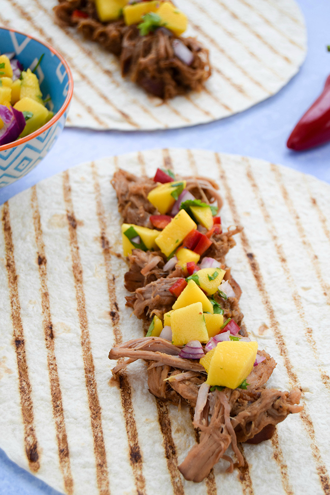 Think your slow cooker is just for winter? Dust it off and try these summery jerk pulled pork tacos with a vibrant chilli mango salsa.
