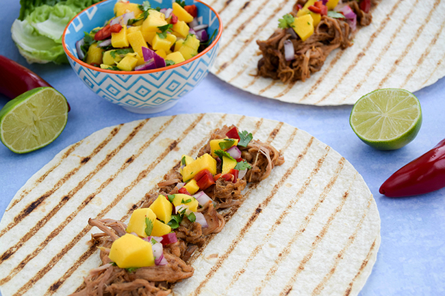 Think your slow cooker is just for winter? Dust it off and try these summery jerk pulled pork tacos with a vibrant chilli mango salsa.