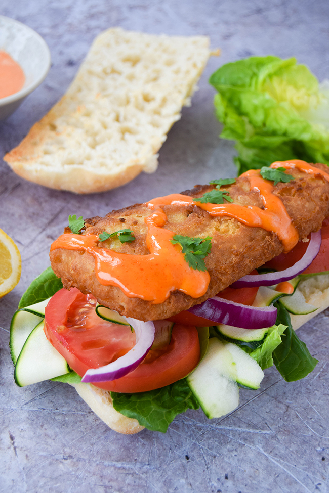 Quick and simple, but doesn't compromise on taste. Speedy comfort food in the form of a chip shop fish sandwich drizzled with sriracha mayonnaise. Quick and simple, but doesn't compromise on taste. Speedy comfort food in the form of a chip shop fish sandwich drizzled with sriracha mayonnaise.